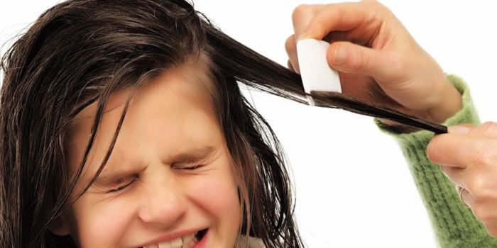 Girl combing her hair with a small comb